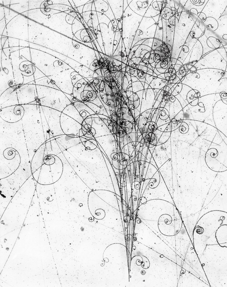 Bubble-chamber photograph of an electromagnetic particle shower: a fan of spiralling tracks.