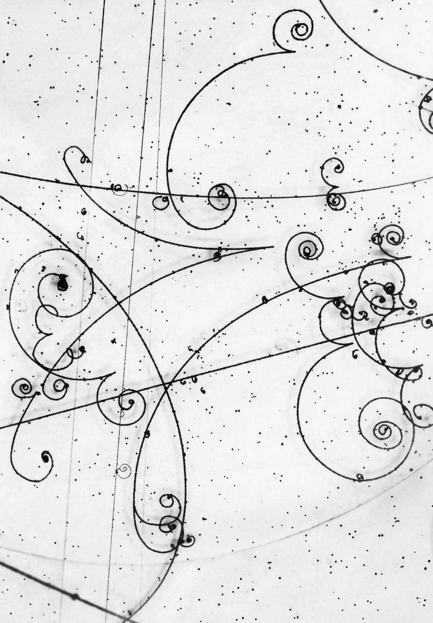 Bubble-chamber photograph of electron and positron tracks curling in a magnetic field.